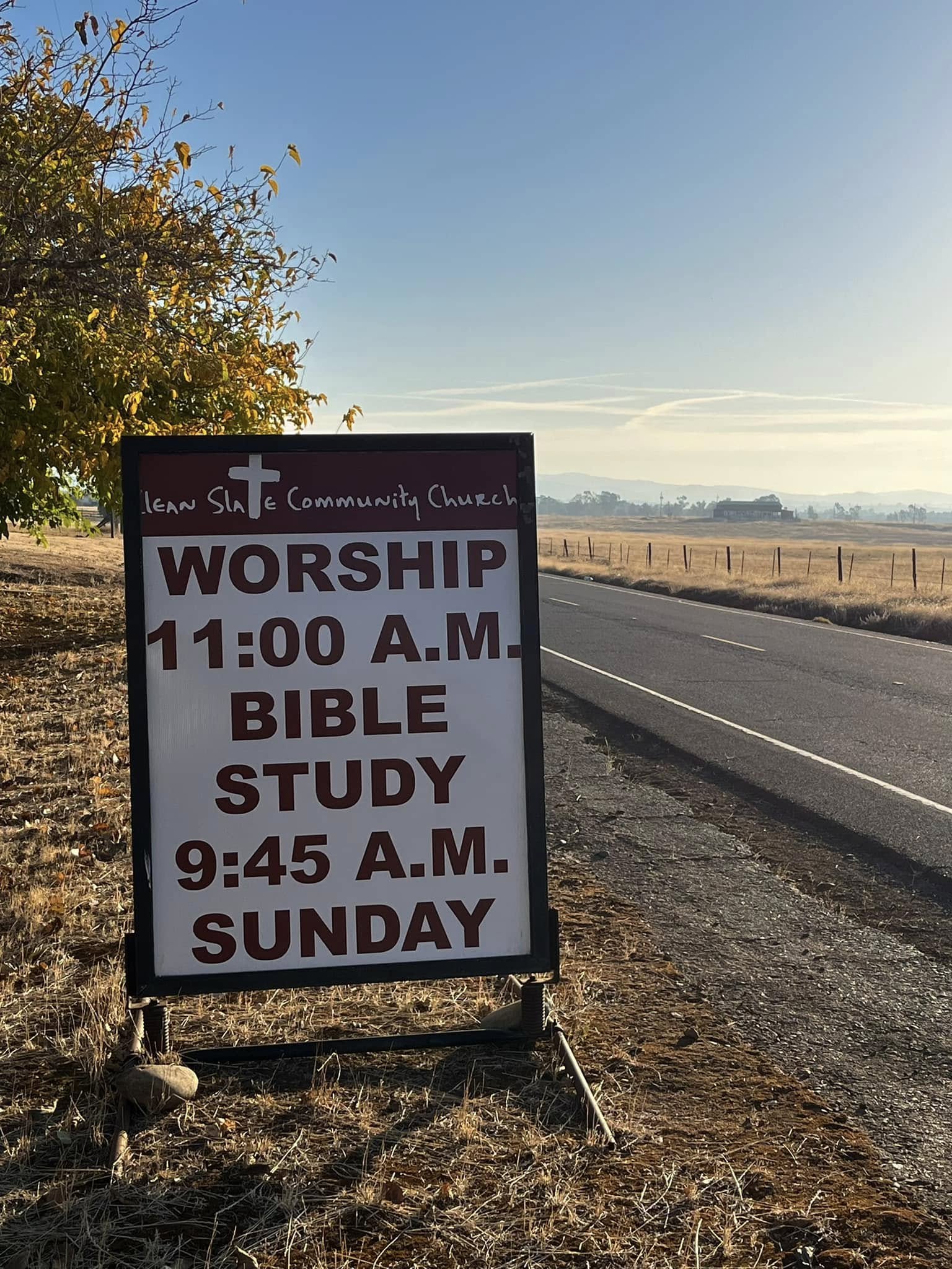Sign for New Site Community Church by a road, announcing 